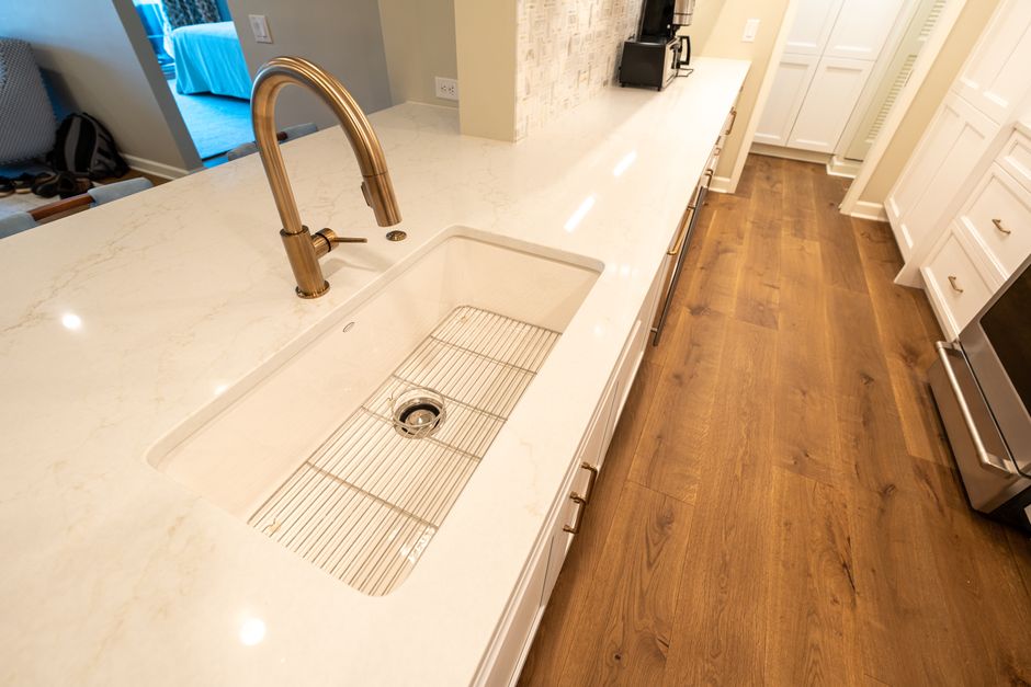 A modern kitchen with a marble countertop and sleek fixtures.